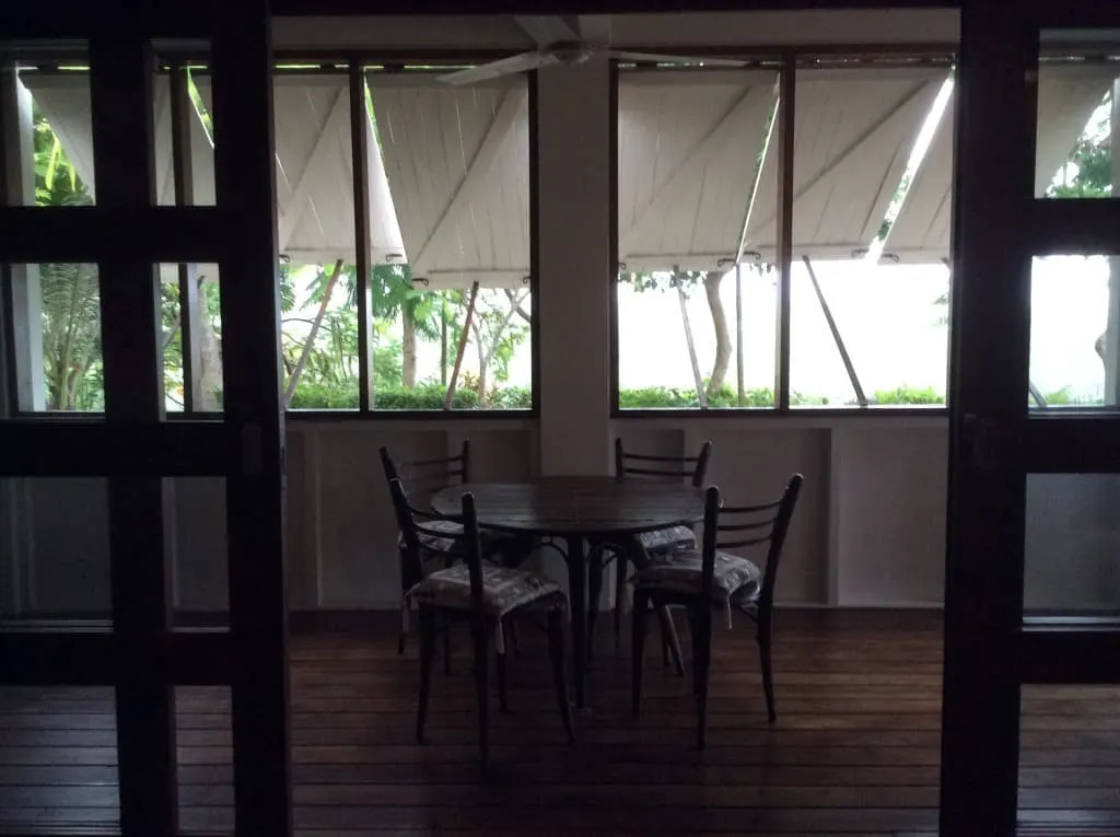 The main house lower level is protected by a wrap-around veranda. Wooden shutters keep the elements at bay from the interior glass and screen openings.