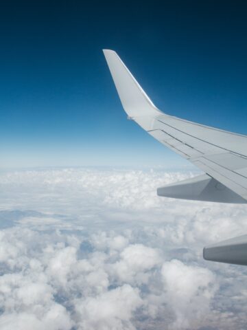 top reasons to move abroad airplane wing