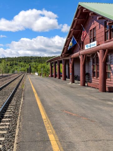 East Glacier Park, Montana, USA - June 7, 2021: A Spring morning view of the platform of the Amtrak Train Station, located just outside of Glacier National Park.