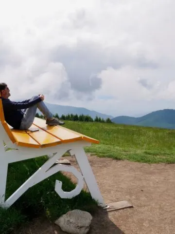 Man sitting on Grone - Colli di San Fermo Big Bench, Lombardy, Italy. High quality photo